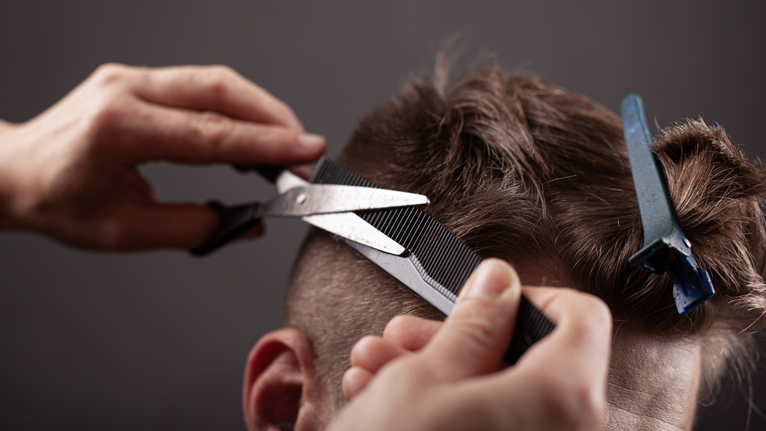 Person Cuts Man's Hair with Scissors